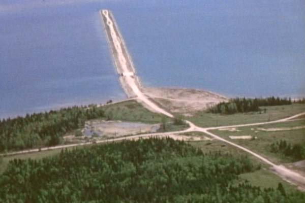Aerial shot of the original 1930s Mackinac Bridge Causeway for the aborted multi-span suspension bridge. Work was halted on this first bridge by World War II, however the causeway ended up saving the 1950s Mackinac Bridge Authority a great deal of money! The east-west road crossing the causeway approach at a right-angle is the now-abandoned Graham St. (c.1954)