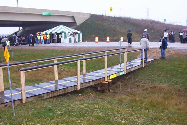 Ribbon-cutting invitees parked their vehicles on the eastbound lanes of the M-6/South Beltline Frwy at Byron Center Ave, while the actual ceremony took place on the westbound lanes. To get from one side of the freeway to the other, MDOT crews constructed.