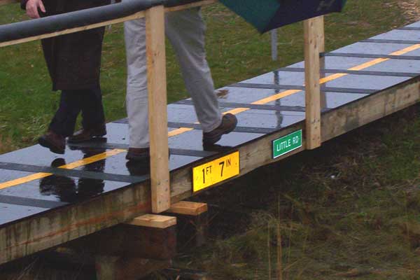 Closeup of the footbridge spanning the freeway median. Note the signs for 'Little Rd' and the underclearance of '1 ft, 7 in.'