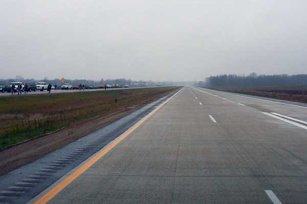 Looking westerly down the new M-6/South Beltline Freeway from immediately west of the Byron Center Ave overpass. The ribbon-cutting ceremonies will be taking place a few hundred feet behind the photographer and you can see the attendees vehicles parked on