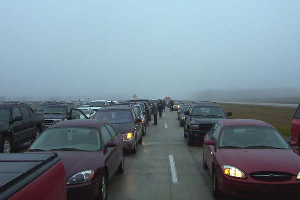 This shot illustrates the long line of cars parked four abreast on the eastbound lanes as well as two abreast on the loop ramp from southbound Byron Center Ave, barely visible in the distance on the left side of the image. 